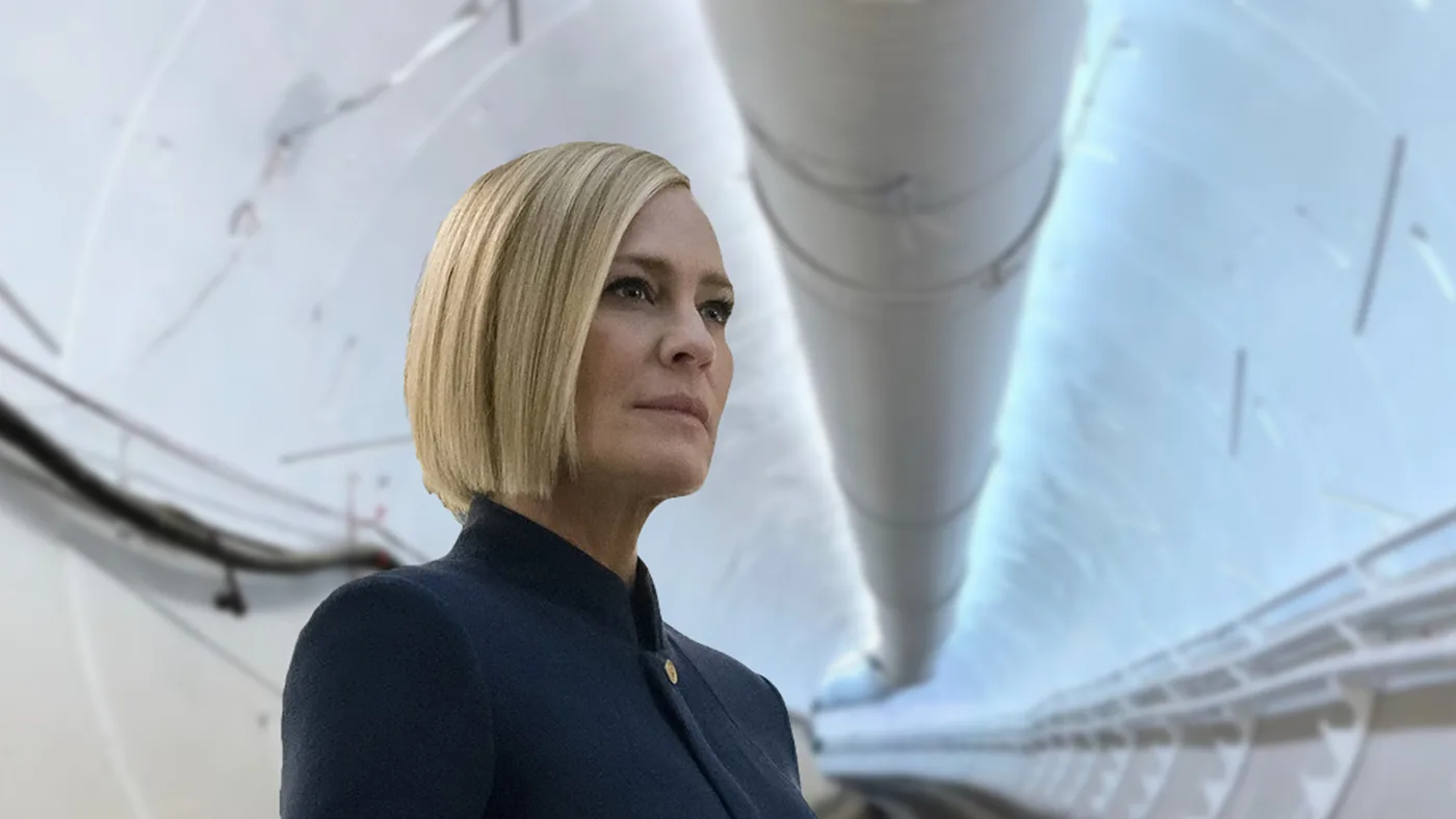 Daniela Hammond in a dark high-collared jacket inside a white transit tube